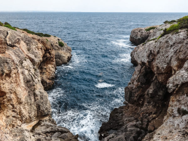 Deep crevice along coastline rough sea