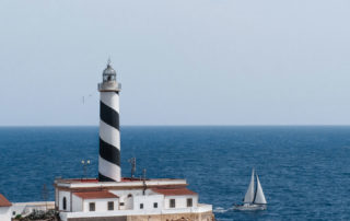 Cala Figuera lighthouse with sailing yacht