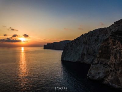 Aerial drone image of sunset over sea with cliffs