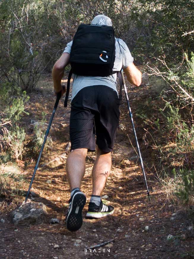 Hiker with back turned ascending steep hill